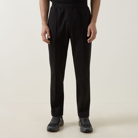 Model wearing Boss Green Label black sweat bottoms in cotton-polyester blend, styled with dark trail trainers