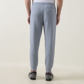 Model wearing Boss Green Label Dark Grey Sweat Bottoms, back view, styled with grey trainers. Elasticated waistband and cuffed ankles visible.