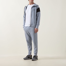 Model wearing Boss Green Label Dark Grey Sweat Bottoms with matching zip-up hoodie and white tee, styled with grey trainers