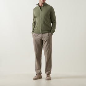 Model wearing Boss Green Label TR Commuter Pleated Trousers in light pastel green, styled with a zip-through khaki sweatshirt and desert boots