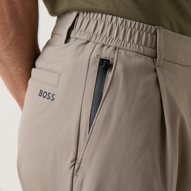 Model wearing Boss Green Label TR Commuter Pleated Trousers in Light Pastel Green, close-up of rear zip welt pocket and elasticated waistband.