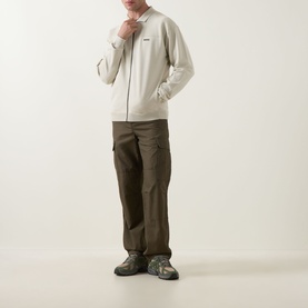 Model wearing Boss Green Label Light Beige zip-through knit, styled with dark khaki cargo trousers and grey hiking boots.