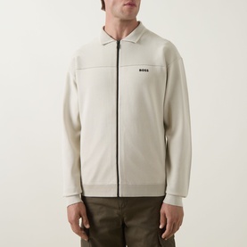 Model wearing Boss Green Label Light Beige zip-through knit jacket with collar, black zip and small logo to chest, styled with khaki trousers.