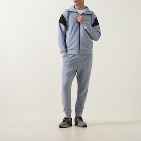 Model wearing Boss Green Label Union Saggy Logo Zip Hoodie in dark grey with black tennis-inspired inserts, styled with matching grey joggers and