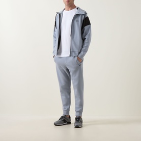 Model wearing Boss Green Label Union Saggy Logo Zip Hoodie in dark grey with matching joggers and grey trainers.