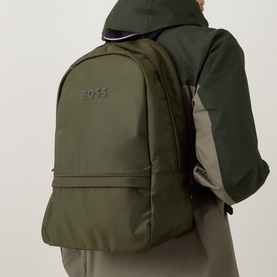Model carrying Hugo Boss Catch 3.0 Backpack in Open Green, tonal logo lettering, subtle satin finish, styled with a khaki jacket