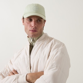 Model with Hugo Boss Derrel Logo Patch Baseball Cap in Open Green, six-panel curved visor, styled with cream bomber jacket