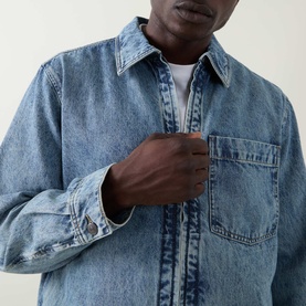 Model wearing Hugo Boss Orange Luney Denim Jacket in mid-wash blue, point collar, front zip fastening and chest patch pocket visible
