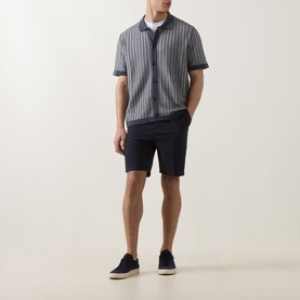 Model wearing Hugo Boss Orange Kodd Stripe Shirt in dark blue, short-sleeve striped knit cardigan, styled with navy shorts and navy trainers.