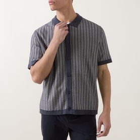 Model wearing Hugo Boss Orange Kodd Stripe Shirt in dark blue, short-sleeve knit with vertical stripes, flat collar, and button fastening