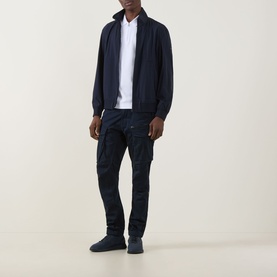 Model wearing Hugo Boss Orange Qlik Logo Windbreaker in dark blue with white shirt, navy cargo trousers and navy trainers