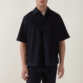 Model wearing Hugo Boss Orange dark blue short-sleeve casual shirt in cotton blend, with spread collar and button placket, paired with dark trousers