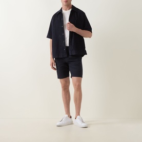 Model wearing Hugo Boss Orange dark blue short-sleeve casual shirt with matching shorts and white trainers.