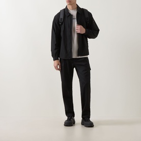 Model wearing Hugo Boss Orange black casual shirt with black trousers, grey top underneath, and black backpack and shoes.