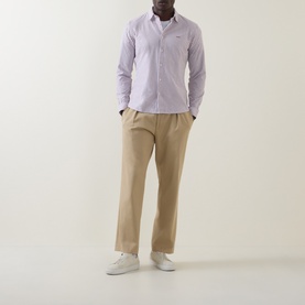 Model wearing Hugo Boss Orange Mysoft Logo Striped Shirt in medium red, styled with beige trousers and white trainers