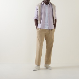Model wearing Hugo Boss Orange Mysoft Logo Striped Shirt in medium red, styled with beige chinos and white trainers.