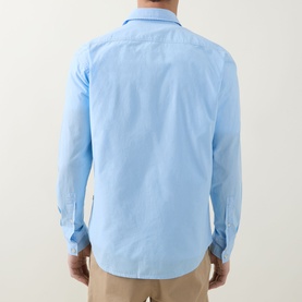 Model wearing Hugo Boss Orange Relegant Logo Casual Shirt in Open Blue, back view, long sleeves, curved hem, paired with beige trousers