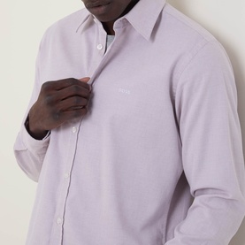 Model wearing Hugo Boss Orange Relegant Tonal Logo Shirt in medium red, featuring pointed collar, long sleeves and button fastenings