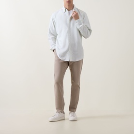 Model wearing Hugo Boss Orange casual shirt in Open Green with taupe chinos and white trainers.