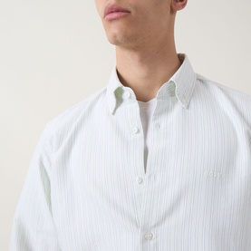 Model wearing Hugo Boss Orange casual shirt in Open Green, fine stripe cotton, with white crew-neck T-shirt visible at neckline