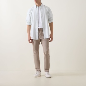 Model wearing Hugo Boss Orange casual shirt in Open Green with taupe slim-fit trousers and white trainers.