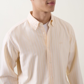 Model wearing Hugo Boss Orange casual shirt in light pastel orange, cotton blend, button-down collar, relaxed fit, styled with white T-shirt