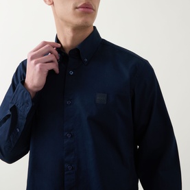 Model wearing Hugo Boss Orange Ricoplus Logo Casual Shirt in dark blue, showing button-down collar, front button fastening and chest logo patch