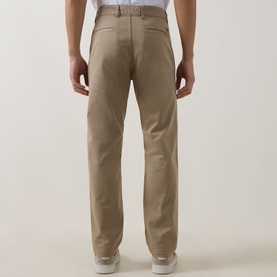 Model wearing Hugo Boss Orange light pastel brown cotton chino trousers, rear view showing clean waistband and straight leg fit