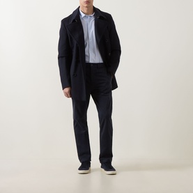 Model wearing Hugo Boss Orange dark blue cotton chino trousers, styled with a navy coat and light blue shirt.