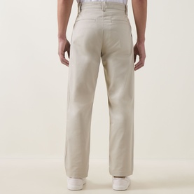 Model wearing Hugo Boss Orange light beige chino trousers, rear view showing relaxed fit, patch pockets and clean waistband finish.
