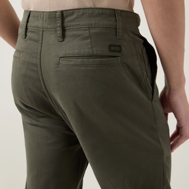 Model wearing Hugo Boss Orange bright green cotton chino trousers, close-up of back pocket and waistband detail