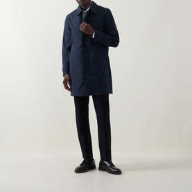 Model wearing Hugo Boss Clark Water Repellent Coat in dark blue with concealed zip placket, styled with black trousers and black shoes.