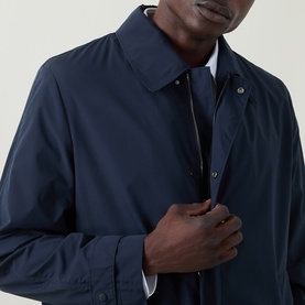 Model wearing Hugo Boss Clark Water Repellent Coat in dark blue, showing pointed collar, concealed zip placket and snap button detail.