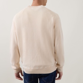 Model wearing Hugo Boss Orange Akapulko Logo Relaxed Fit Sweater in light pastel orange, crew neck, rear view, styled with dark jeans