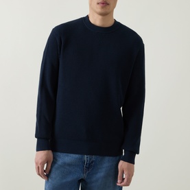 Model wearing Hugo Boss Orange Akipano Dark Blue knitted crew neck sweater with ribbed trims, styled with blue jeans