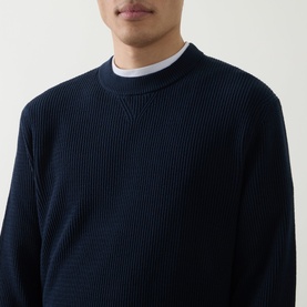 Model wearing Hugo Boss Orange Akipano Knitted Sweater in dark blue, ribbed knit crew neck, styled with white collared shirt underneath