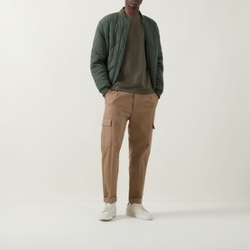 Model wearing Hugo Boss Orange Bright Green crew neck cotton T-shirt, styled with olive bomber jacket and tan cargo trousers.