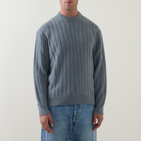 Model wearing Hugo Boss Orange Arkingo Texture Rib Sweater in Open Grey, vertical knit crew neck, styled with light wash jeans