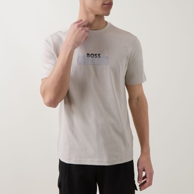 Model wearing Hugo Boss Orange light beige crew neck T-shirt with tonal chest logo graphic, paired with black trousers