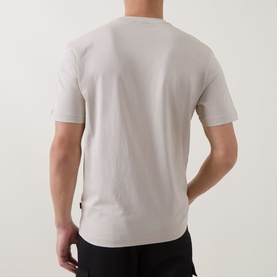 Model wearing Hugo Boss Orange light beige cotton crew neck T-shirt, rear view, styled with black trousers
