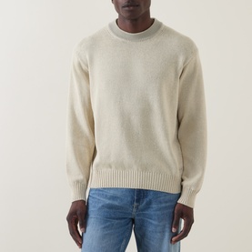 Model wearing Hugo Boss Orange Kosido Light Beige knitted crew neck sweater with ribbed trims, styled with blue jeans.