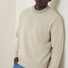 Model wearing Hugo Boss Orange Kosido Knitted Sweater in light beige, crew neck with ribbed trims, styled with blue jeans