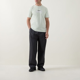 Model wearing Hugo Boss Orange Open Green crew neck T-shirt with small chest logo, styled with dark wide-leg trousers and black shoes.