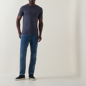 Model wearing Hugo Boss Orange Tales Logo T-Shirt in dark blue with blue jeans and navy trainers.