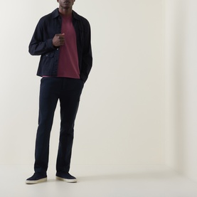 Model wearing Hugo Boss Orange Tales Logo T-Shirt in Medium Red, styled with navy overshirt, navy trousers, and grey slip-on shoes.