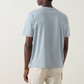 Model wearing Hugo Boss Orange Tchup Tonal Logo T-Shirt in Open Grey, back view, crew neck, short sleeves, styled with cream trousers