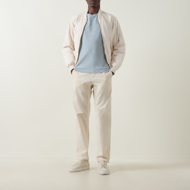 Model wearing Hugo Boss Orange Tchup Tonal Logo T-Shirt in Open Grey, styled with cream bomber jacket, ecru chinos and grey trainers.
