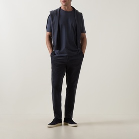 Model wearing Hugo Boss Orange T Chup Logo T-Shirt in dark blue, crew neck, styled with navy trousers and navy slip-on shoes.
