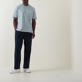 Model wearing Hugo Boss Orange Te Frame Logo Back Graphic T-Shirt in Open Grey with navy trousers and white trainers.