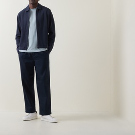 Model wearing Hugo Boss Orange Te Frame Logo Back Graphic T-Shirt in Open Grey, styled with navy zip jacket, navy trousers, and white trainers.